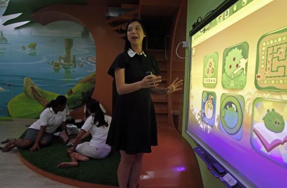 Dreamkids Kindergarten principal Choy shows how the Smart Board is used for educational games in class as teachers plan their lessons in an Angry Birds-inspired classroom environment in Singapore